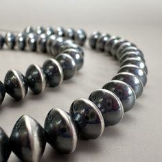 The oxidized, brushed silver finish of these handmade beads make them beautiful to wear on their own or as an elegant accent to any gemstone. The saucer shape is such a great addition as focal point - wow! The high and lowlights on this bead (also known as a navajo pearl) make it significantly special. We love these! 8mm Smooth Saucer Bead Quantity: 1 piece Dimensions: Diameter: 8mm Length: 5.2mm Hole size: 1.6mm Sterling Silver Base bead made in China, and hand-finished in the USA by Navajo sil High And Lowlights, Silver Bead, Handmade Beads, Oxidized Sterling Silver, How To Make Beads, Silver Beads, Focal Point, 1 Piece, China