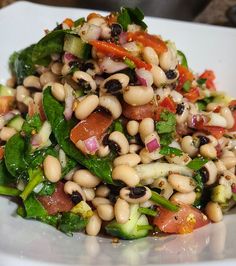 a white plate topped with beans and veggies