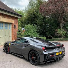 a grey sports car parked in front of a garage