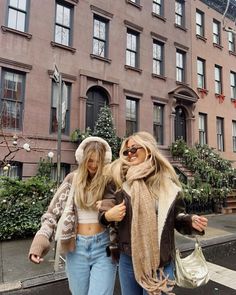 two women are walking down the street together