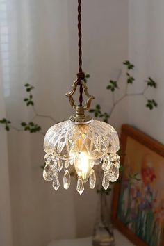 a chandelier hanging from a ceiling in a room with a painting on the wall