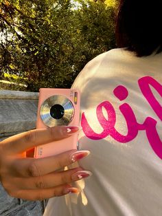 a woman taking a photo with her pink camera