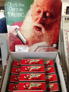 a display in a store filled with lots of red and green boxes next to a sign that says give the gift of music