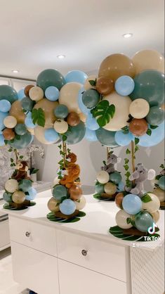 balloons are arranged on top of a dresser in a room with white walls and flooring