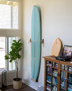 Premium oak vertical surfboard rack designed by Raili Design Co. artfully displays surfboards on any wall vertical, creating a unique coastal wall art aesthetic for surf shacks worldwide. Surfboard Hung On Wall, Mounted Surfboard Decor, Surfboard Interior Design, Surf Board Display, Vertical Surfboard Wall Mount, Surfboard Display Ideas, Surfboard Mounted On Wall, Surf Board Wall Mount, Hanging Surfboard On Wall