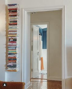 there is a book shelf on the wall by the door in this room that has books all over it