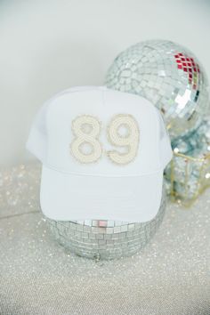 We are obsessed with these custom Judith March Beaded number hats! Whether you want your team number, enneagram, or favorite date, we will customize it for you. Number patches are only available in the White Beaded patch style. **If this product is purchased without adding/paying for custom numbers, your order will be cancelled. This item cannot be purchased plain.** Since this item is custom, we do not offer refunds, exchanges, or store credit. Once a custom order is placed, we are unable to ch White Snapback Trucker Hat For Party, White Snapback Party Hat, White Trucker Baseball Cap For Party, White Snapback Hat For Party, White Adjustable Baseball Cap For Party, Customizable White Adjustable Snapback Hat, Customizable Adjustable White Snapback Hat, Customizable White Hat For Birthday, White Personalized Snapback Hat With Curved Brim