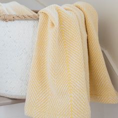 a yellow and white blanket sitting on top of a basket