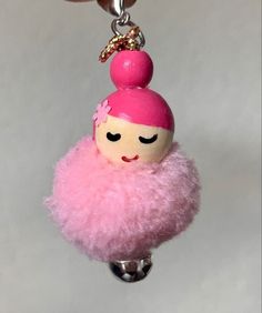 a key chain with a pink ballerina doll hanging from it's back end