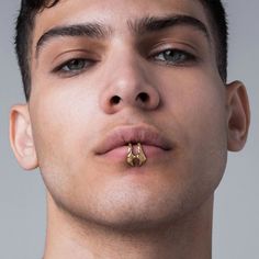 a young man with a nose piercing in gold