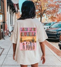 Long Live Cowgirls Shirt is a perfect addition to your summer wardrobe, with its coastal cowgirl graphics and oversized tee design making it an ideal choice for a day at the beach or a country concert in Nashville. Whether you're a preppy coconut girl or just love the yeehaw aesthetic, this shirt is a must-have for any cowgirl at heart:) **USUALLY SHIPS WITHIN 1-4 DAYS** ABOUT PRODUCT: -Comfort Colors Shirt -The tee is a dyed, soft-washed fabric. -The loose shape makes it a great daily wear.  -T Oversized Summer Tops For Rodeo, Casual Letter Print Shirt For Rodeo, Summer Graphic Print Shirt For Rodeo, Summer Graphic Print Tops For Rodeo, Graphic Print Tops For Summer Rodeo, Casual Shirt With Letter Print For Rodeo, Crew Neck Shirt For Summer Rodeo, Oversized Tops For Summer Rodeo, Cotton Shirt For Summer Rodeo