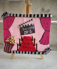 an easel with a pink and black painting on it