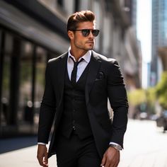 a man in a suit and sunglasses walking down the street with his hand in his pocket