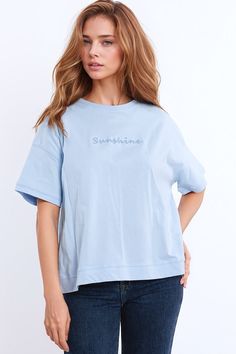 Elevate your casual wardrobe with this charming and super comfortable oversized t-shirt featuring textured fluffy text at the front spelling the word "sunshine." Perfect for adding a touch of whimsy to your everyday look.    Design:  Oversized t-shirt with a classic crew neckline and short sleeves for a relaxed and laid-back vibe.   Textured Text:  Delightful fluffy text at the front spells out the word "sunshine," adding a playful and cheerful element to the design.   Fabric:  Crafted from 100% cotton for a soft and breathable feel, ensuring comfort all day long.   Fit:  Relaxed fit and oversized silhouette offer a comfortable and effortless look.   Styling:  Pair with denim shorts and a cardigan for the perfect spring ensemble, ideal for casual outings or relaxed weekends.   Sizing:  Ava Blue Relaxed Fit Top With Embroidered Text, Blue Tops With Embroidered Text And Relaxed Fit, Blue Tops With Embroidered Text For Spring, Oversized Short Sleeve Top With Embroidered Text, Oversized Tops With Embroidered Text For Everyday, Oversized Top With Embroidered Text For Everyday, Everyday Spring Top With Embroidered Text, Spring Everyday Top With Embroidered Text, Oversized Top With Embroidered Text For Spring