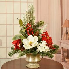 a gold vase filled with flowers on top of a table