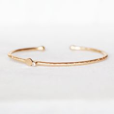 "Elegant, modern and sparkly! Hand forged out of 2mm 14k gold with a 2mm white diamond and a handmade petal. The cuff is not hollow, it is solid gold all the way through. The diamond and petal are set off-center on the cuff. I balled the ends with my torch. Simple and elegant, the perfect skinny cuff for every day wear! Diamond - 2mm I1 White, conflict-free Gold - 2mm 14k Cuff is 5.5\"L and has an opening of approximately 1\". It fits medium to small wrists and is slightly adjustable. If you wou Minimalist Diamond Cuff Bracelet As A Gift, Minimalist Diamond Cuff Bracelet For Anniversary, Gold Cuff Bracelet With Single Diamond As Gift, Minimalist Bangle With Single Cut Diamonds For Gift, Minimalist Bangle With Single Cut Diamonds, Recycled Gold Jewelry, Hand Jewelry Rings, Sweet Jewelry, Custom Bracelet