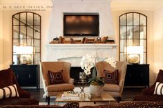 a living room filled with furniture and a flat screen tv mounted on the wall above a fireplace