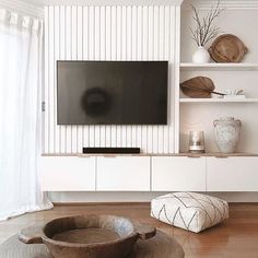 a flat screen tv sitting on top of a white entertainment center