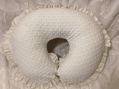 a white pillow that is shaped like a donut with ruffles on it