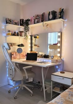 a white desk with a laptop computer on top of it next to a mirror and shelves