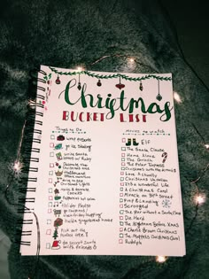 a christmas bucket list with lights on the floor next to it and a gray blanket