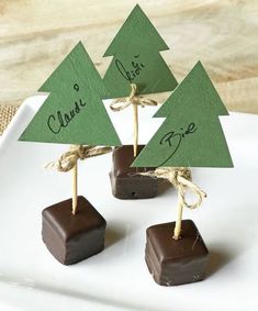 three small trees are on top of chocolate candies with twine tied around them