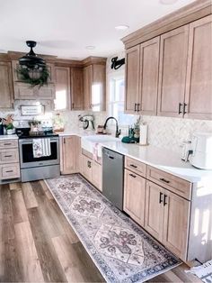 a kitchen with wooden cabinets and white counter tops, an area rug on the floor