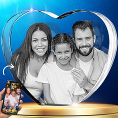 a heart shaped glass photo frame with a family in it