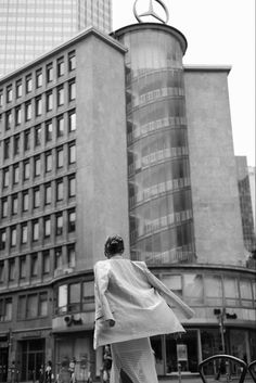 a woman walking down the street in front of tall buildings