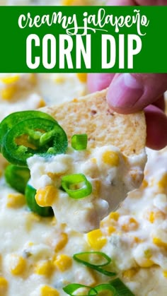 a hand holding a tortilla chip with corn dip in it and green peppers on top