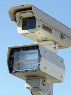 two cameras on top of each other in front of a blue sky