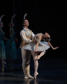 two ballerinas in tutu and leorboam, one holding the other's leg