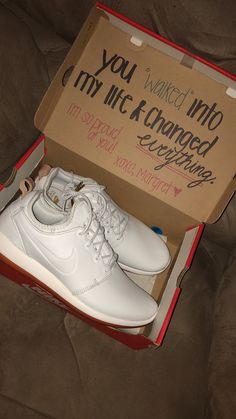 a pair of white nike shoes in a box