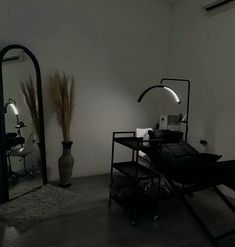 a black and white photo of a desk in a room with mirrors on the wall