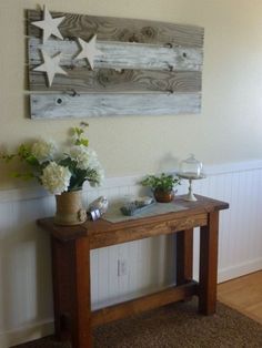 a wooden table with flowers on it in front of a white wall that says this 4th of july, i made my own flag