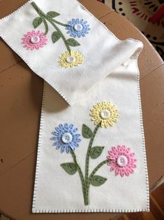 two napkins with embroidered flowers on them