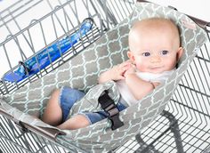 a baby sitting in a shopping cart with his pacifier hanging from it's side