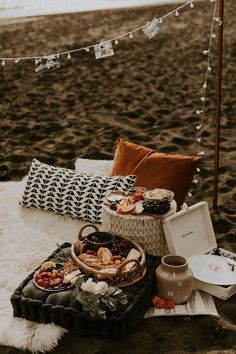 a picnic set up on the beach with food and drinks laid out in front of it