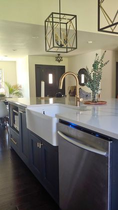 a modern kitchen with stainless steel appliances and white counter tops is pictured in this image