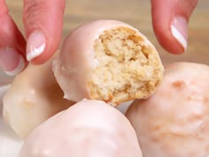 a person holding a half eaten doughnut in their hand and the other half bitten