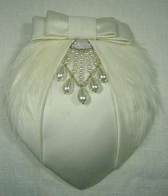 This unique deco bridal hat is strongly influenced by 1930s styling and takes elements from vintage bridal pieces. It was created with lightly padded off-white satin over a lightweight straw base, with a hand stitched soft feather trim and a glass bead and silver wire decoration. The piece is completed with a tailored satin bow. The reverse is finished with traditional millinery petersham and a comb bound with satin ribbon. The hat is 12.5cm at the widest point and 15cm long. The comb will sit s Fascinator Hats Diy, Beaded Headpiece, Fascinator Wedding, Hat Art, Bridal Hat, Feather Wedding, Feather Trim, Diy Hat, Pink Feathers