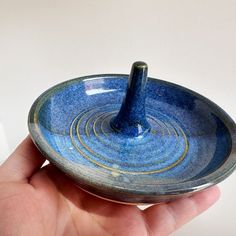 a hand holding a blue and white bowl