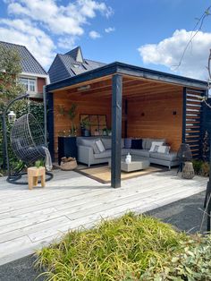 an outdoor living area with couches, chairs and a pergolated deck in the background