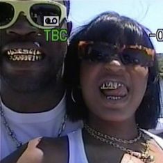 a man and woman with fake teeth on their faces are seen in this screen capture