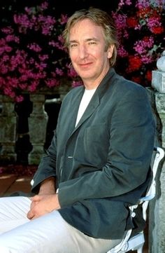 a man sitting on a bench in front of flowers