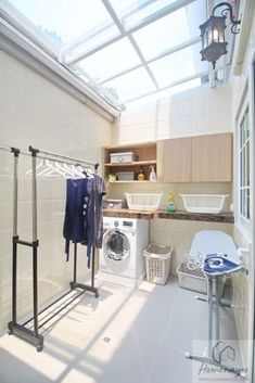 a washer and dryer sitting in a room next to a laundry basket with clothes hanging on it