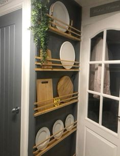 the shelves are filled with plates and cutting boards