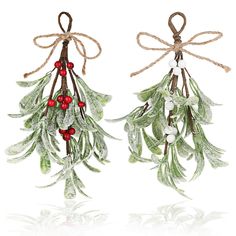 two christmas decorations with mist and berries hanging from twine