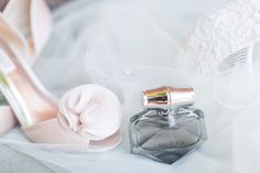 a pair of wedding shoes and perfume bottle