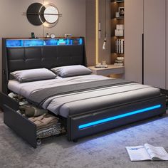 a bed with blue lights under it and a book on the floor next to it